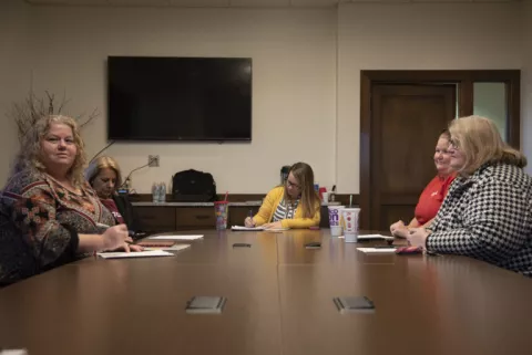 HEA members gather at a long table discussing answers of school board candidates they spoke to