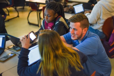 Mr. Born stops at a student's desk to help them